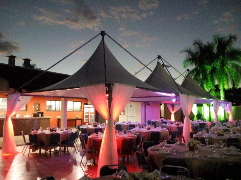 Tendas com cortinas e iluminação colorida em festa à noite